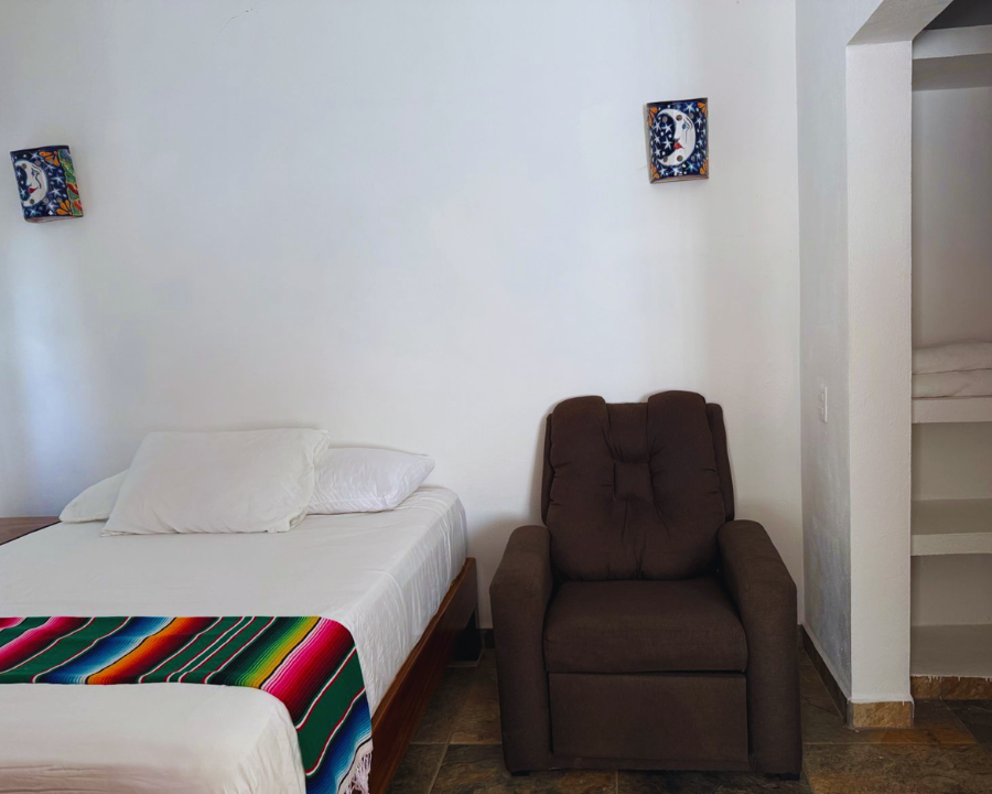 Sala de estar en Casa Eclipse con sillón individual y sofá cama para huéspedes adicionales